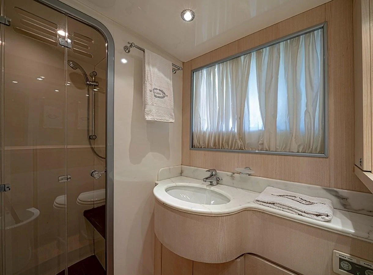 The yacht's bathroom features a sleek design with a glass-enclosed shower and a modern sink area. aboard WHITE & SILVER Yacht for Sale