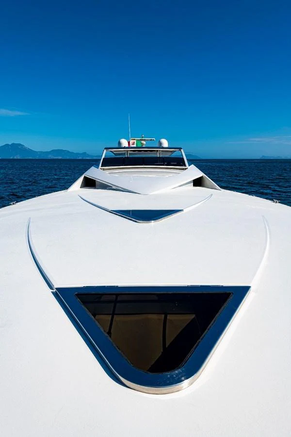 The yacht's sleek bow cuts through the water under a clear blue sky. aboard WHITE & SILVER Yacht for Sale