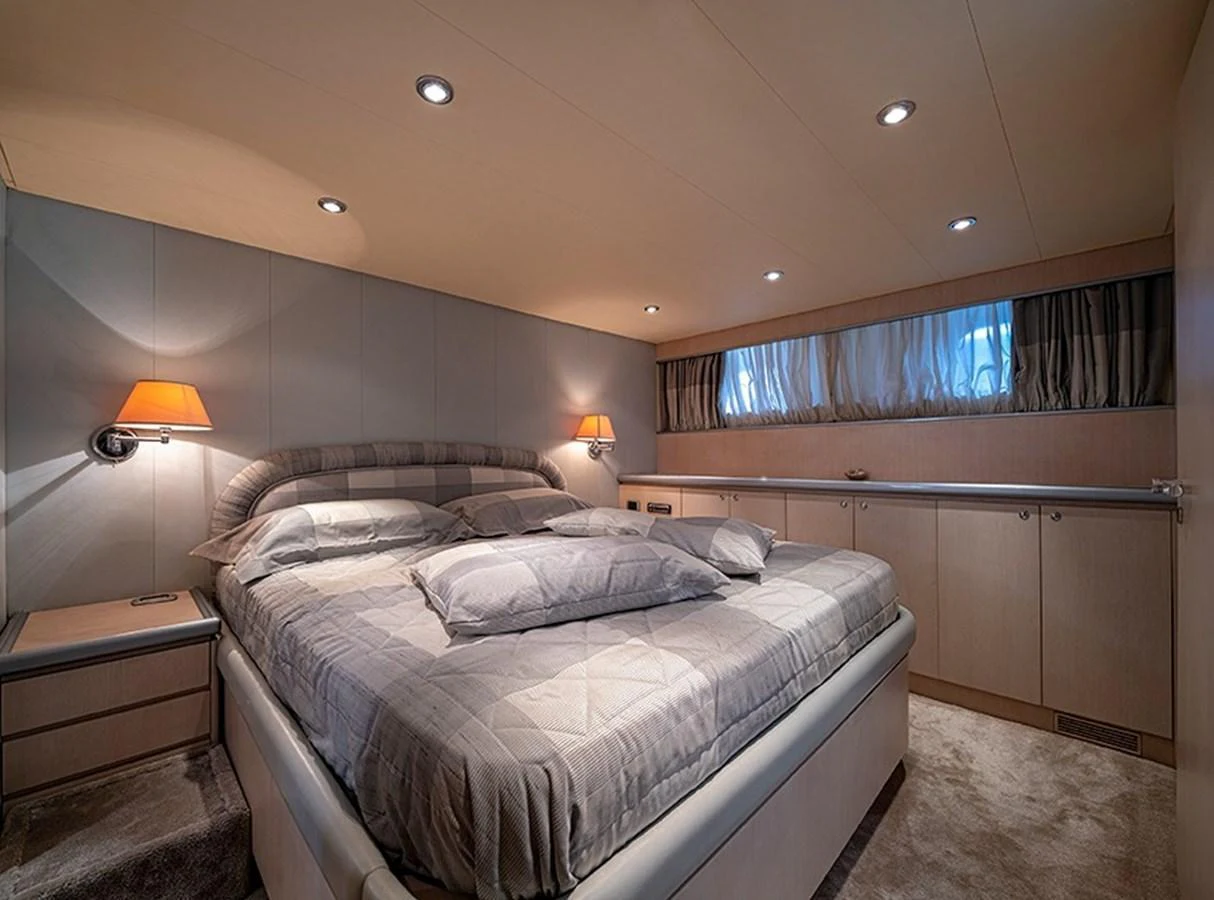 The stateroom features a plush bed with elegant lighting and ample storage, creating a cozy and luxurious retreat. aboard WHITE & SILVER Yacht for Sale