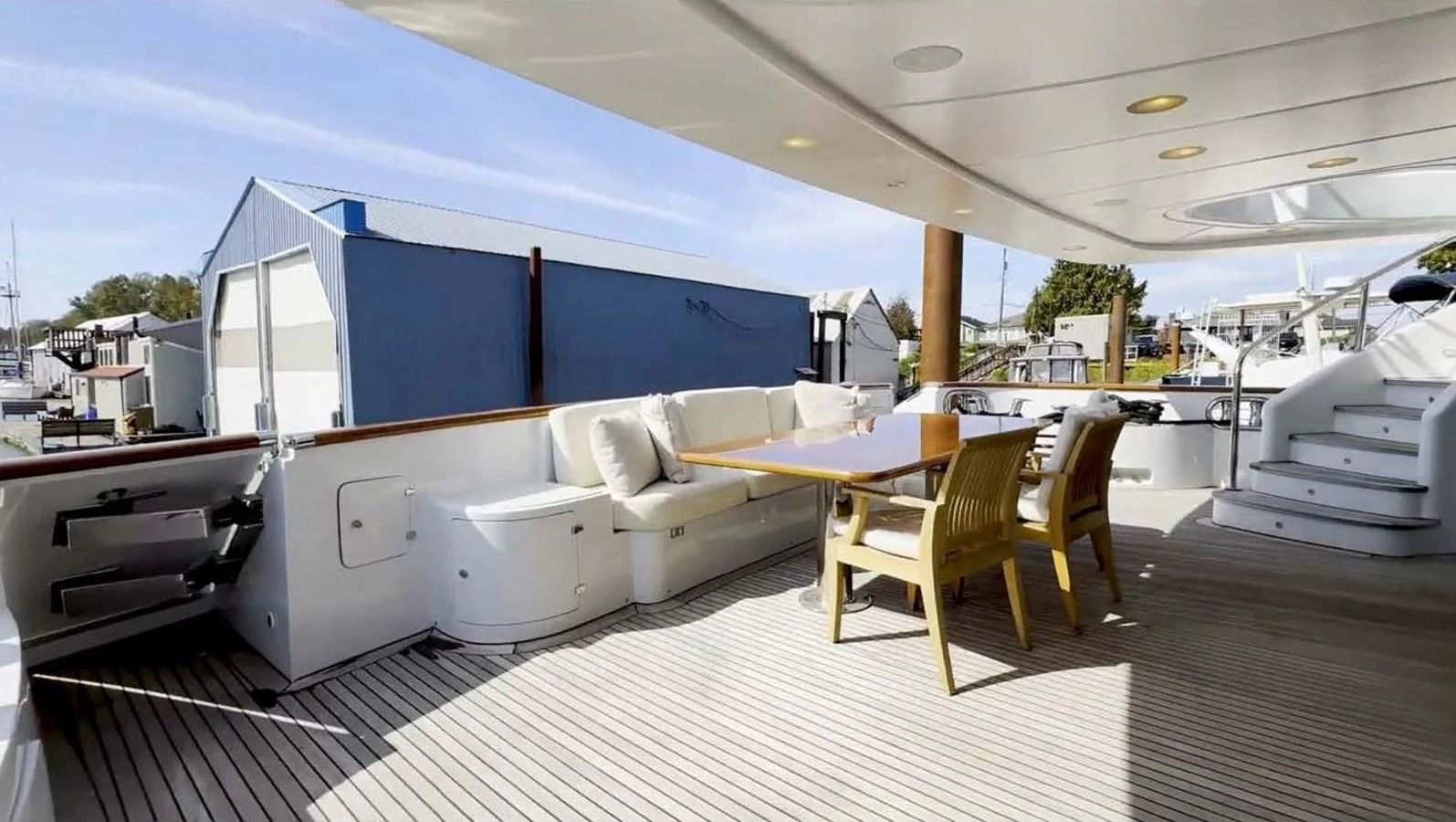 The aft deck features a spacious seating area with a dining table, perfect for alfresco meals. aboard DOMANI Yacht for Sale