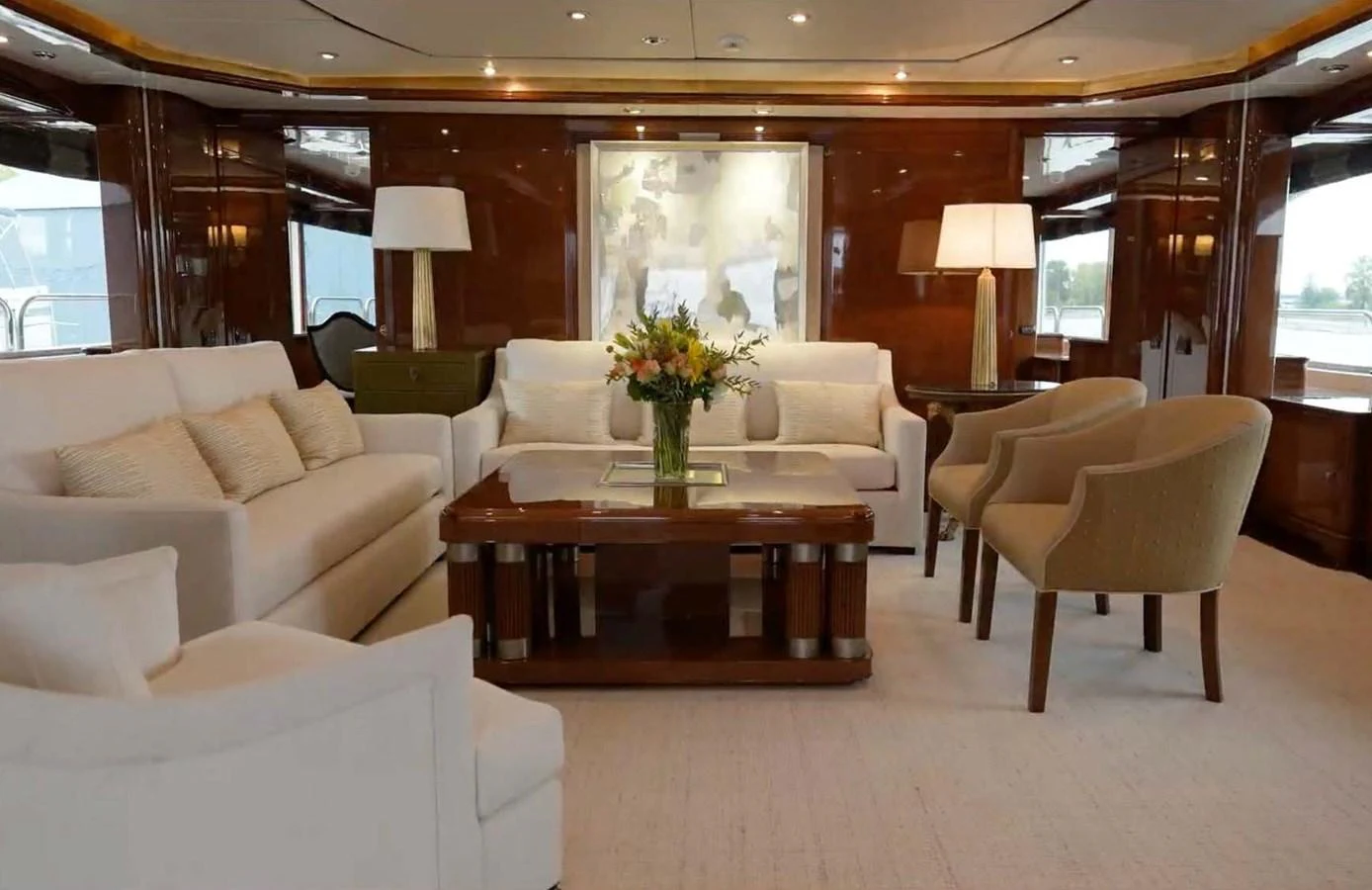 The salon features elegant seating with plush sofas and armchairs, complemented by tasteful decor and ambient lighting. aboard DOMANI Yacht for Sale