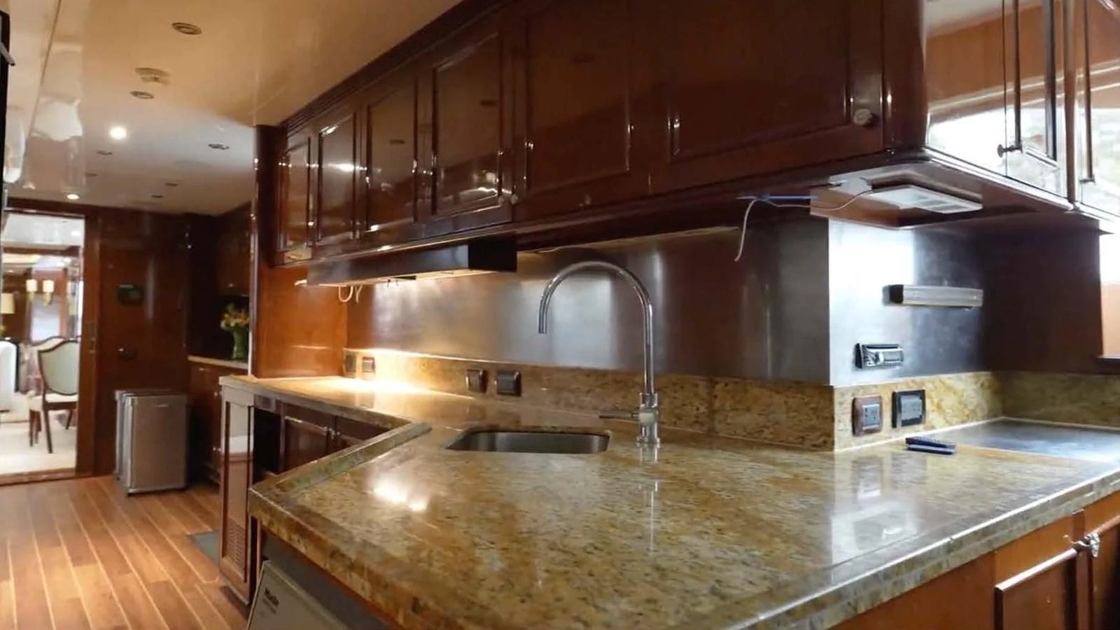 The yacht's galley features elegant wooden cabinetry and a spacious countertop. aboard DOMANI Yacht for Sale