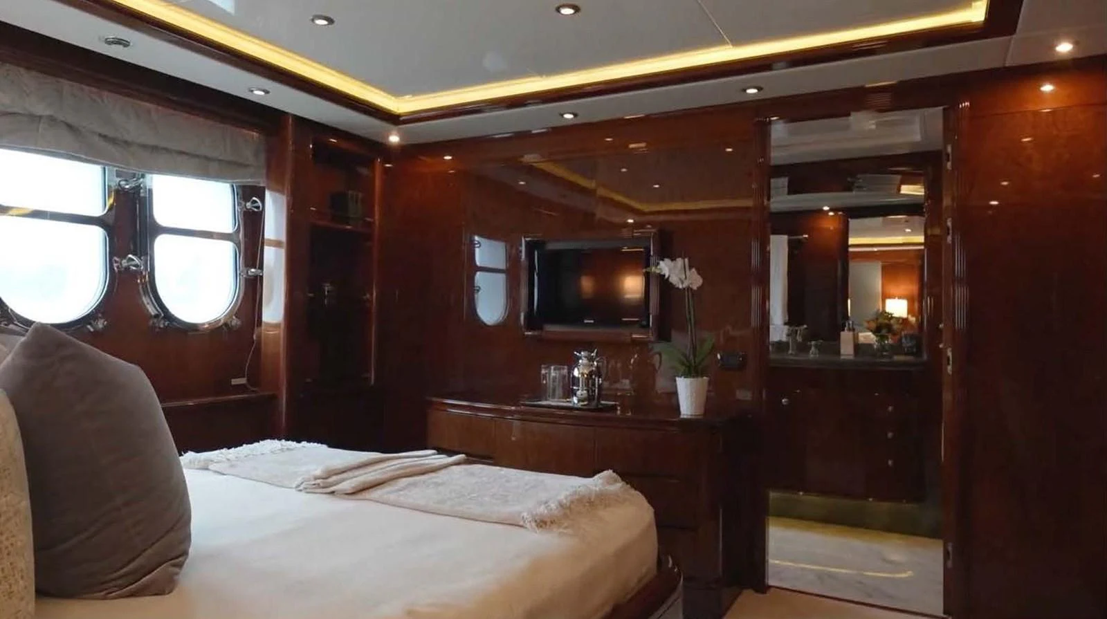 The master stateroom features luxurious wood paneling and modern amenities for ultimate comfort. aboard DOMANI Yacht for Sale
