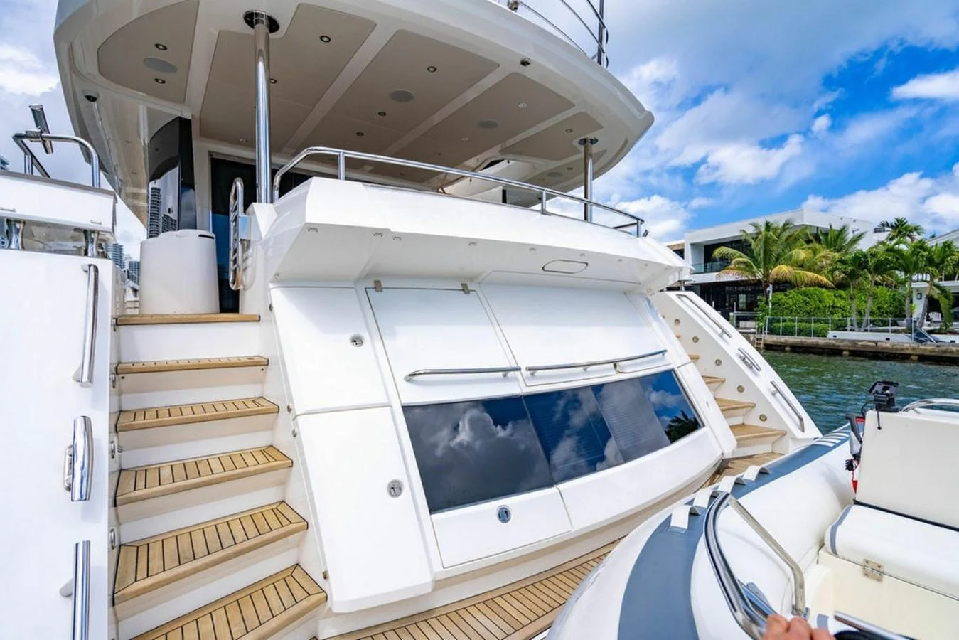 The yacht's aft deck features a sleek design with teak steps and stainless steel railings, leading down to the water level. aboard STAR OF THE SEA Yacht for Sale