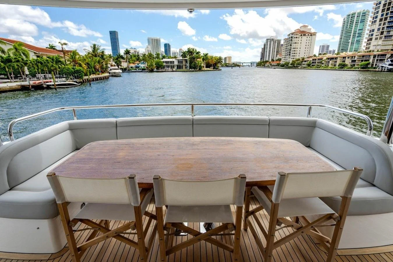 The aft deck features a spacious dining area with a wooden table and comfortable seating, offering stunning waterfront views. aboard STAR OF THE SEA Yacht for Sale