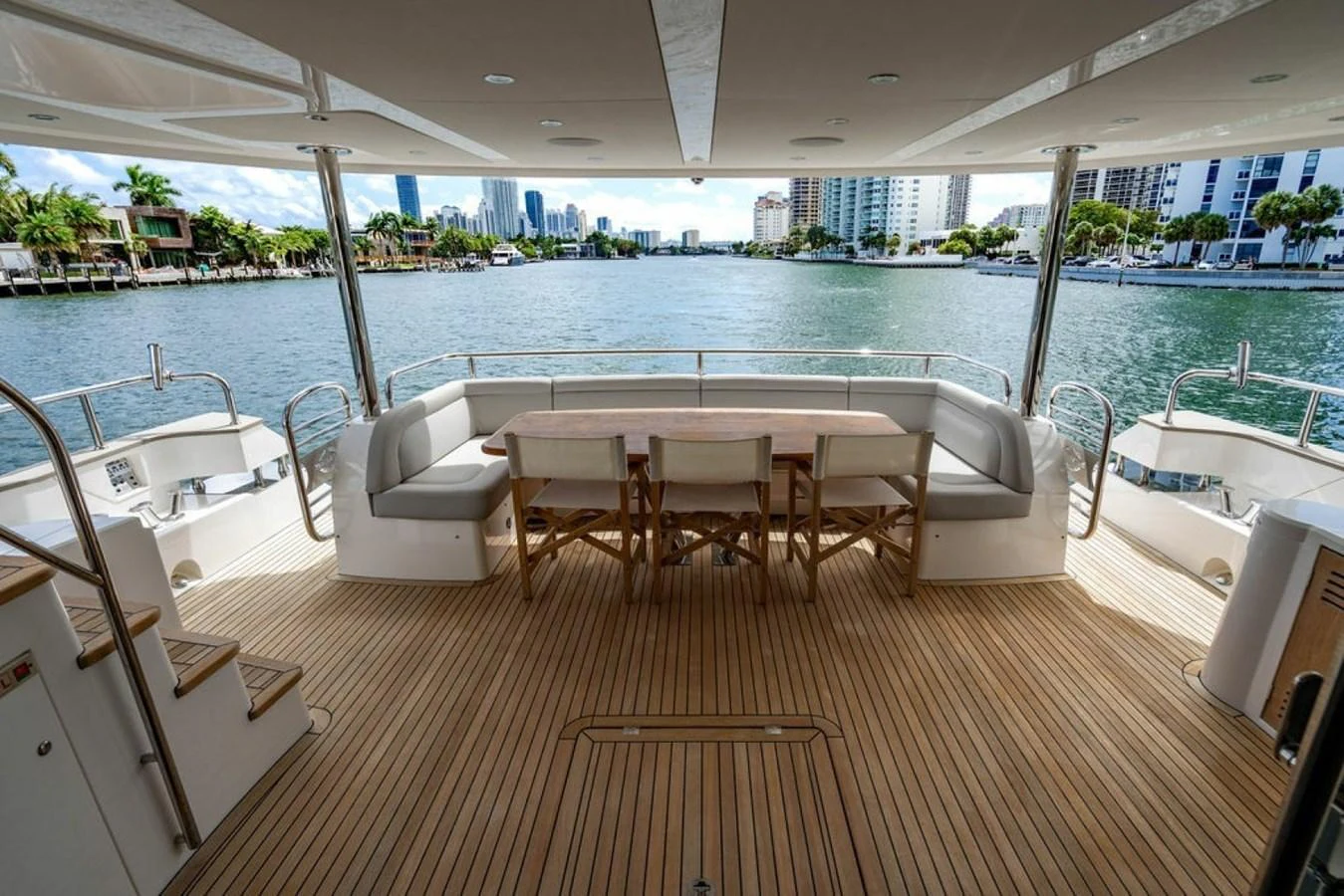 The aft deck features a spacious seating area with a wooden table, perfect for alfresco dining with a view of the water. aboard STAR OF THE SEA Yacht for Sale