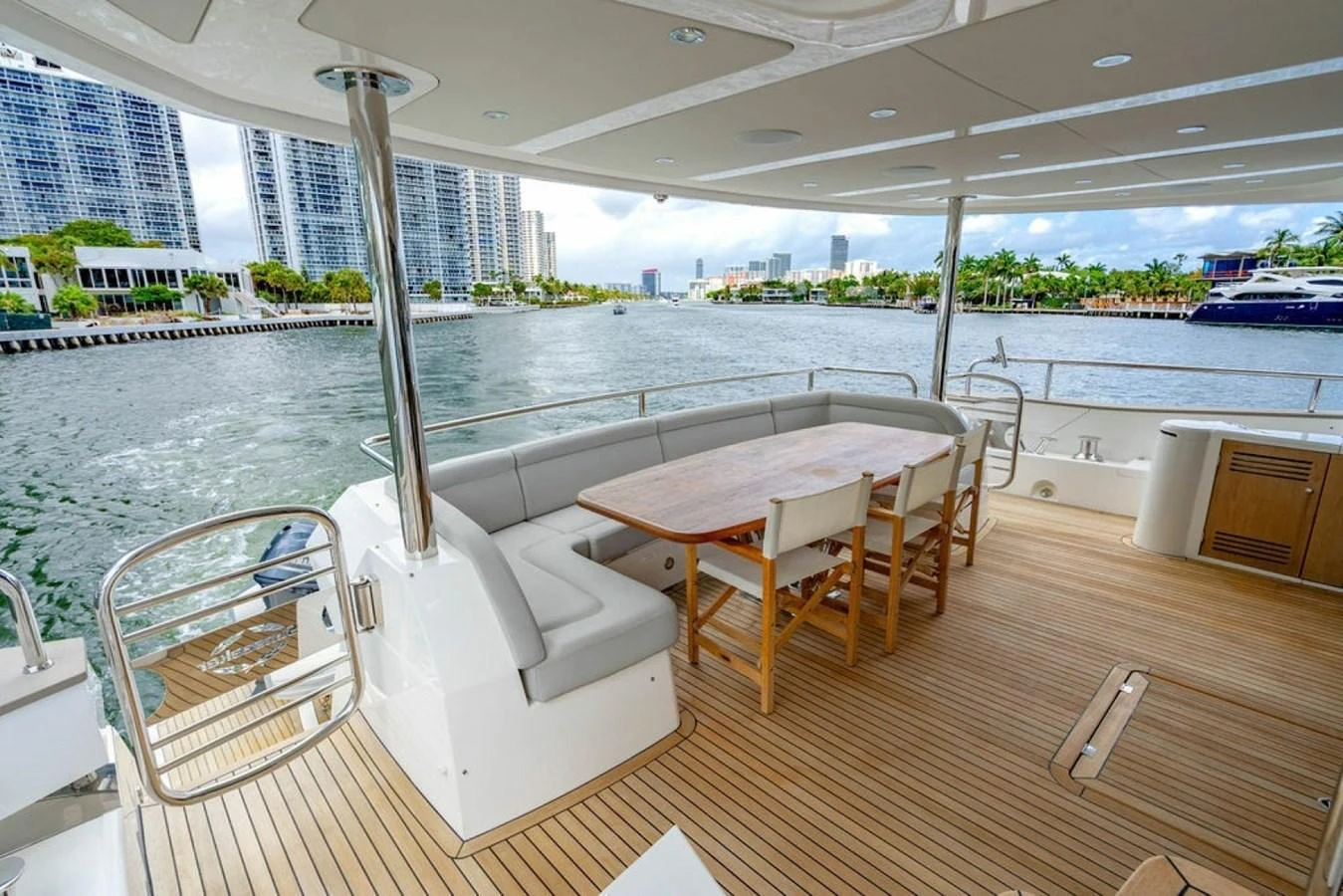 The aft deck features a spacious seating area with a wooden dining table, perfect for alfresco dining while enjoying the waterfront views. aboard STAR OF THE SEA Yacht for Sale