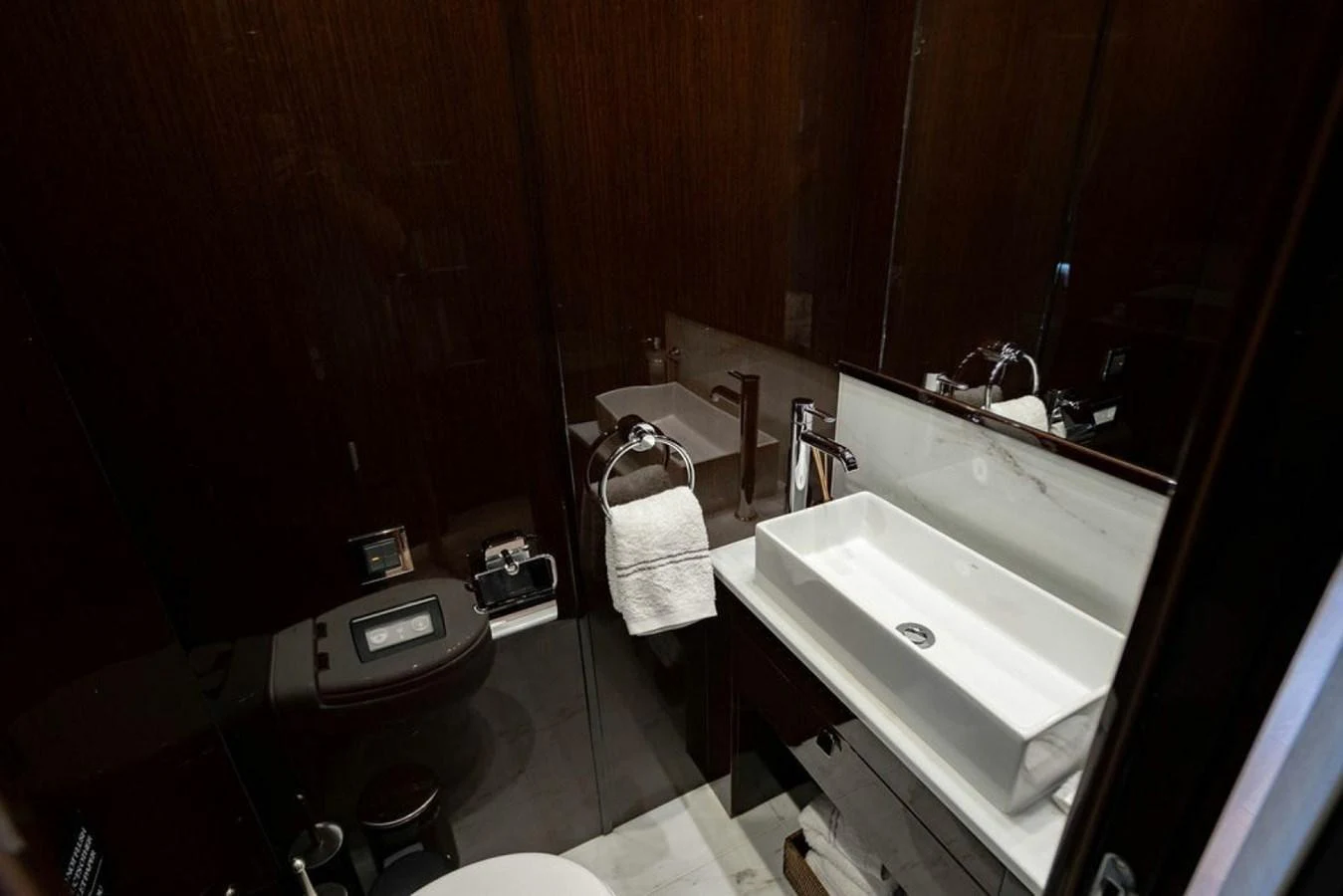 The yacht's bathroom features a sleek, modern design with dark wood finishes and a contemporary sink. aboard STAR OF THE SEA Yacht for Sale