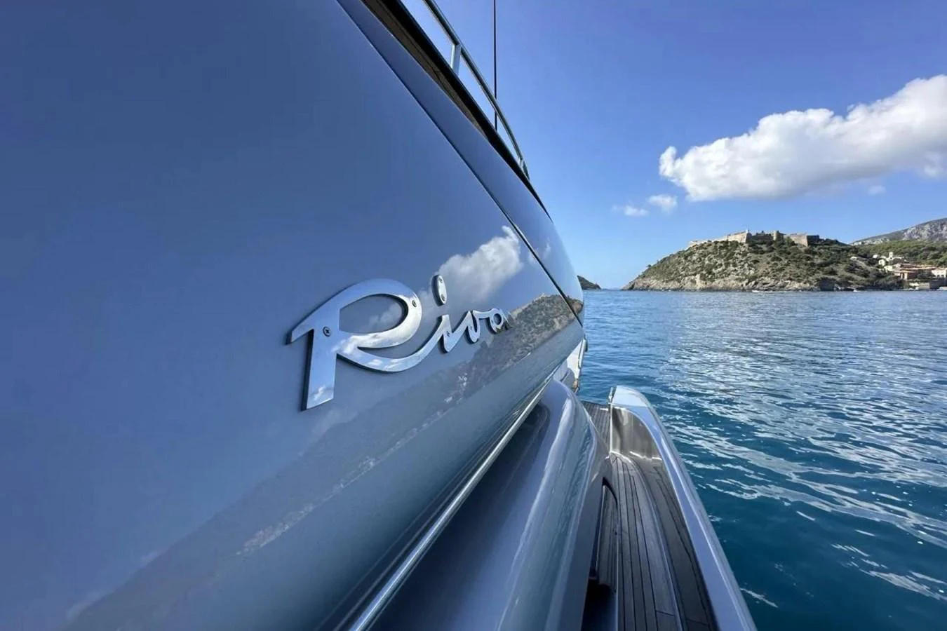 A close-up of the yacht's sleek exterior with a scenic backdrop of the sea and distant hills. aboard SPEEDY BEAR Yacht for Sale