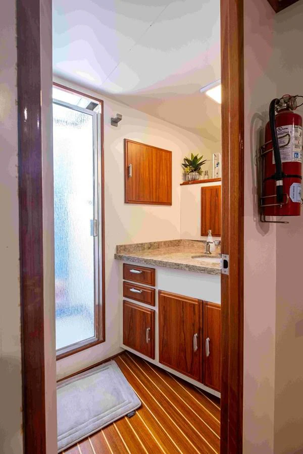 The yacht's bathroom features a sleek design with wooden cabinetry and a modern sink. aboard SAPPHIRE SEA II Yacht for Sale