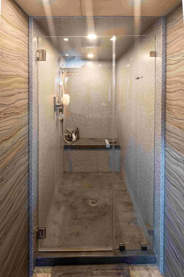 The yacht features a sleek and modern shower with glass doors and elegant stone walls. aboard SAPPHIRE SEA II Yacht for Sale