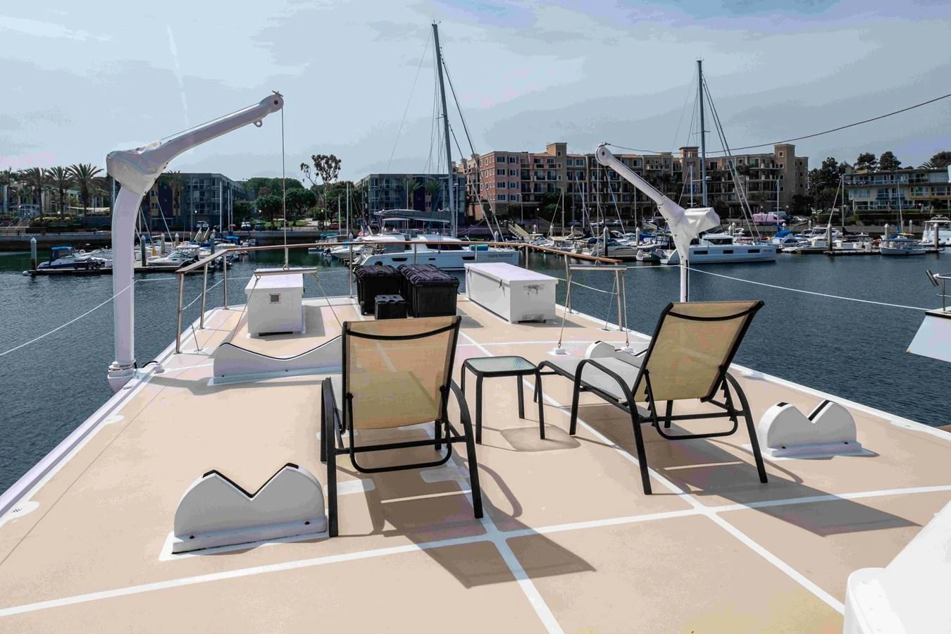 The sundeck offers a relaxing space with lounge chairs and a scenic view of the marina. aboard SAPPHIRE SEA II Yacht for Sale