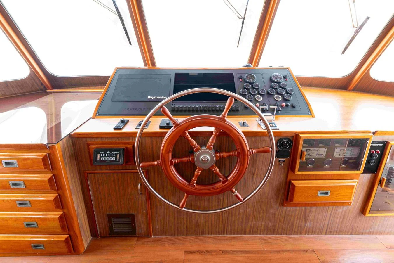 The helm station features a classic wooden steering wheel and modern navigation equipment. aboard SAPPHIRE SEA II Yacht for Sale