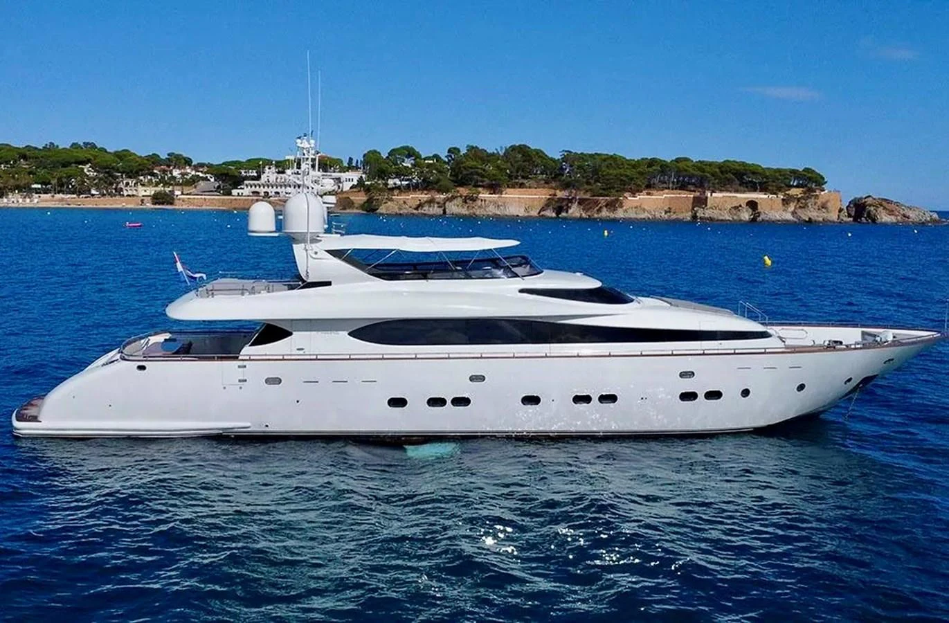A sleek and modern yacht cruising on calm blue waters with a scenic coastal backdrop. aboard BALANDRAU Yacht for Sale