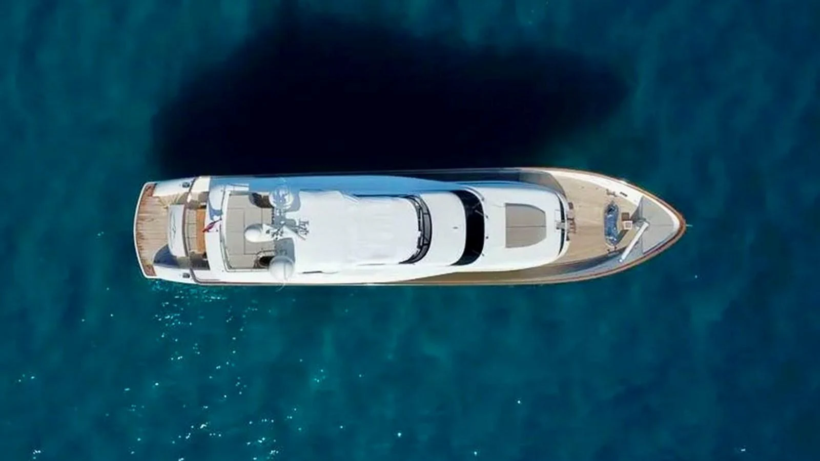 A stunning aerial view of a sleek yacht cruising through clear blue waters. aboard BALANDRAU Yacht for Sale