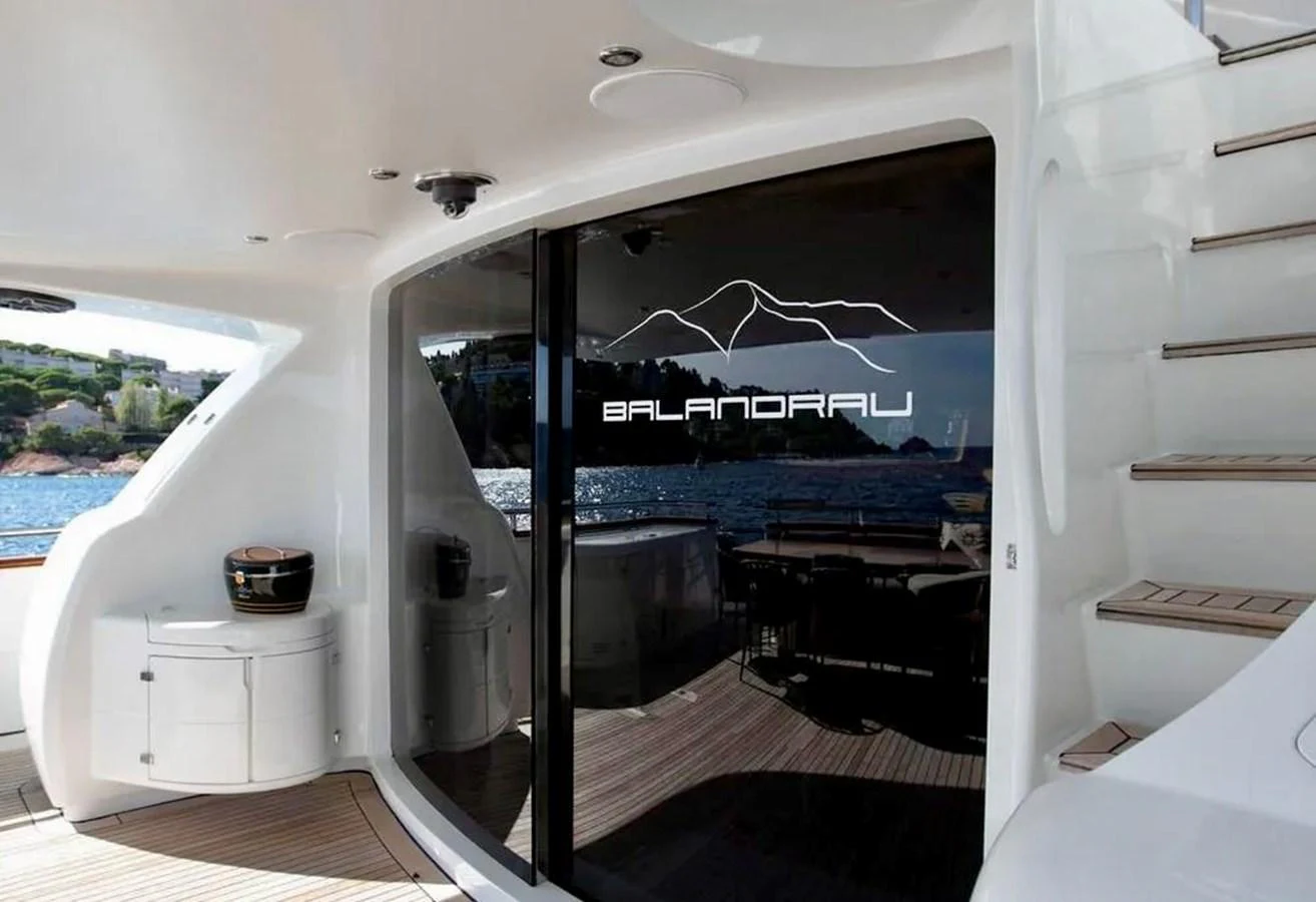 The aft deck features a sleek design with access to the interior and a view of the surrounding waters. aboard BALANDRAU Yacht for Sale