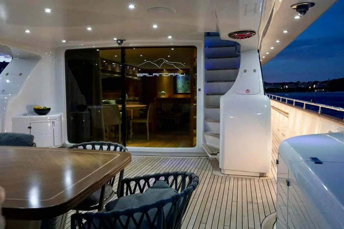 The aft deck features a stylish dining area with comfortable seating and ambient lighting. aboard BALANDRAU Yacht for Sale