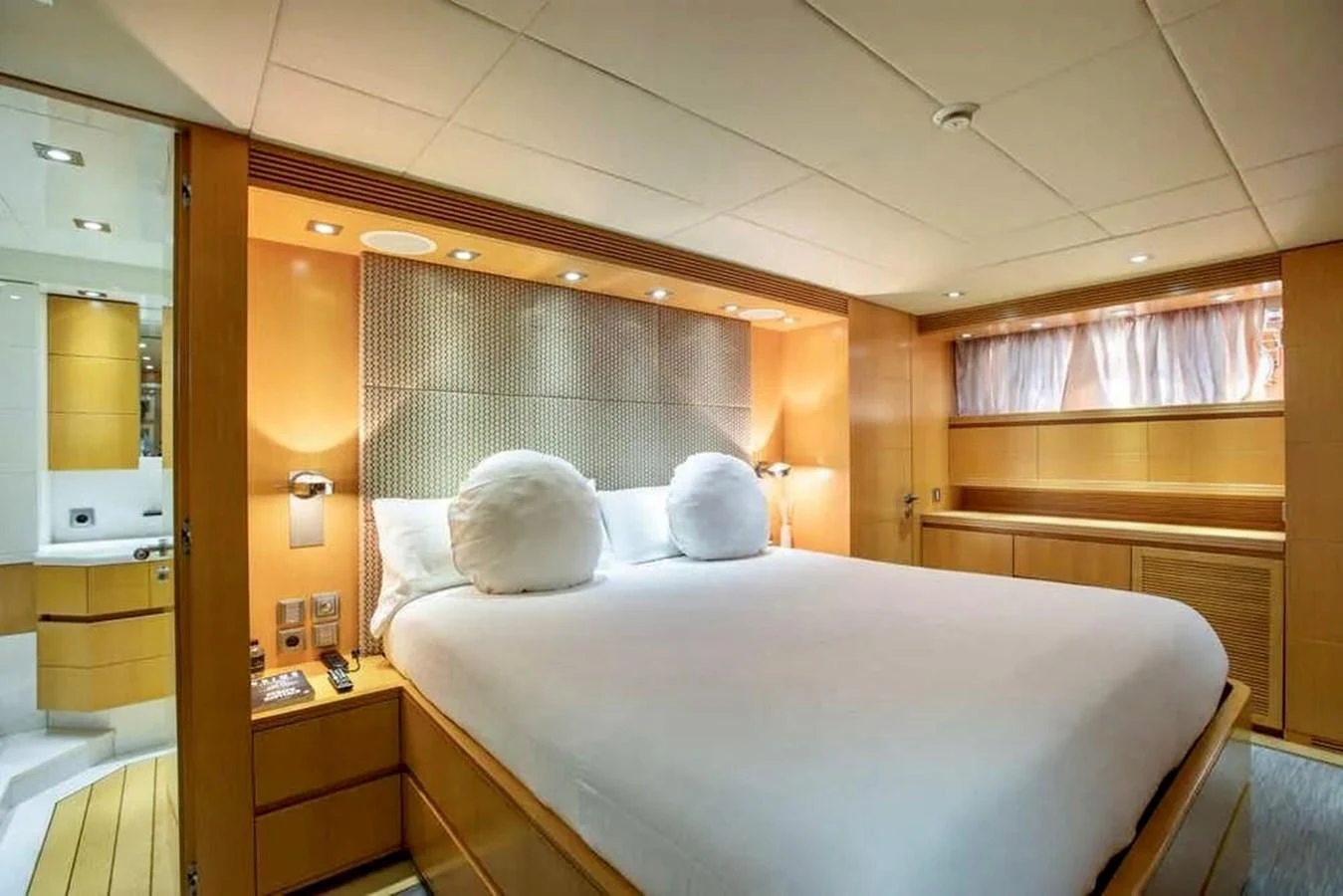 The master stateroom features a luxurious bed with elegant lighting and ample storage space. aboard BALANDRAU Yacht for Sale
