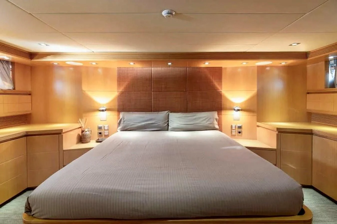 The master stateroom features a spacious bed with elegant wood paneling and ambient lighting. aboard BALANDRAU Yacht for Sale