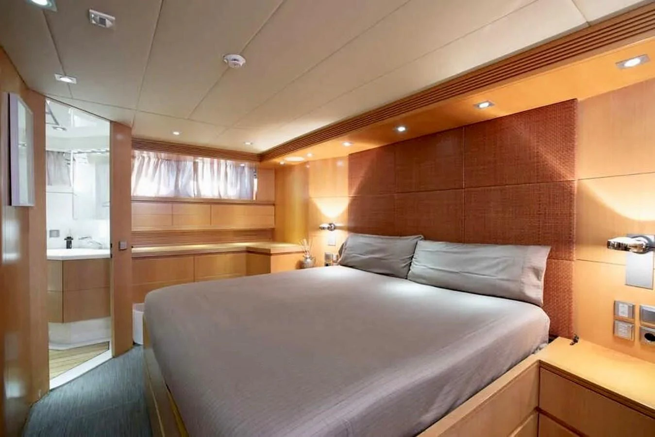 The master stateroom features a spacious bed and elegant wood paneling. aboard BALANDRAU Yacht for Sale