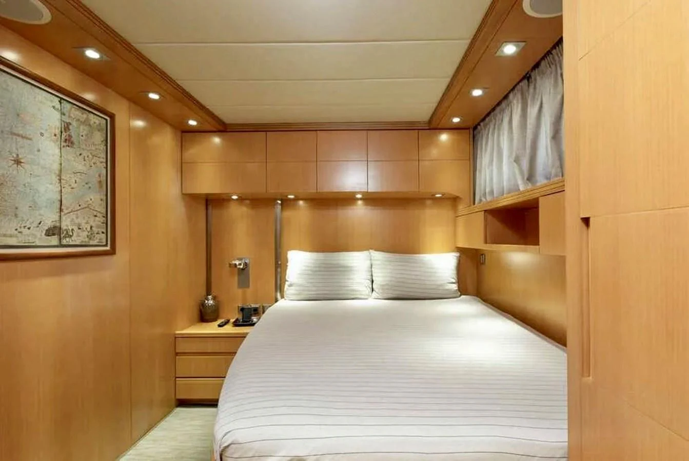 A cozy stateroom with warm wood paneling and soft lighting. aboard BALANDRAU Yacht for Sale