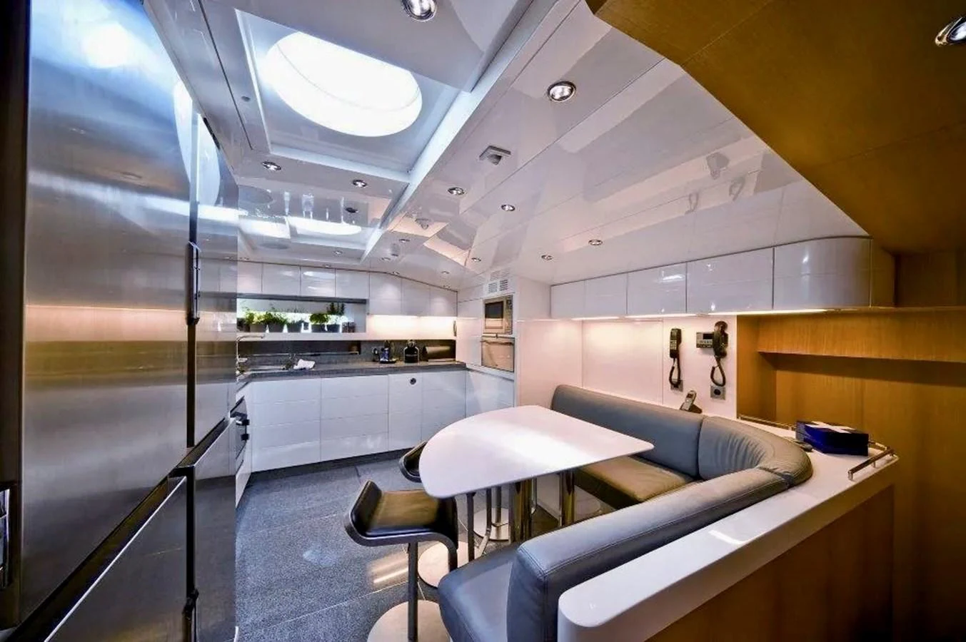 The yacht's galley features modern appliances and a cozy dining area under a skylight. aboard BALANDRAU Yacht for Sale