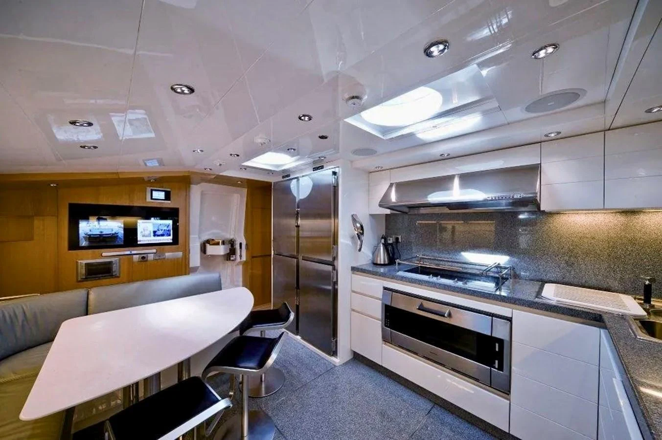 The yacht's galley features modern appliances and a sleek dining area. aboard BALANDRAU Yacht for Sale