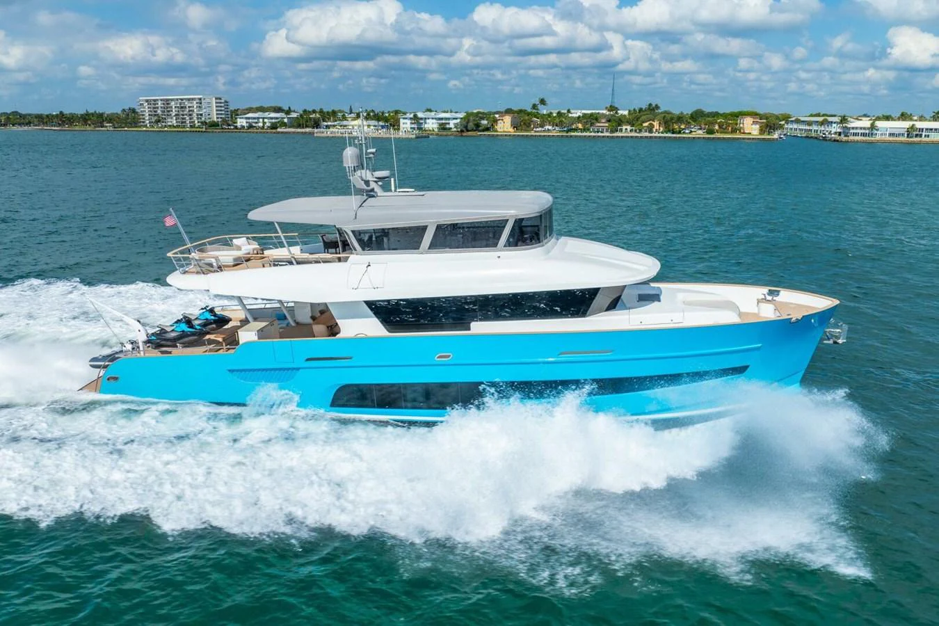 A sleek yacht cruises through the water, showcasing its modern design and vibrant blue hull. aboard LADY SADIE Yacht for Sale
