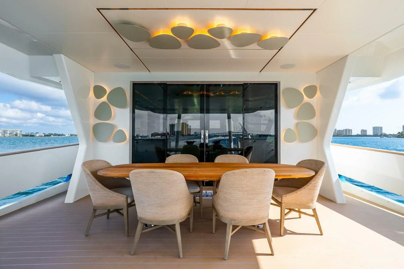 The aft deck features a stylish dining area with a wooden table and comfortable chairs, perfect for enjoying meals with a view. aboard LADY SADIE Yacht for Sale