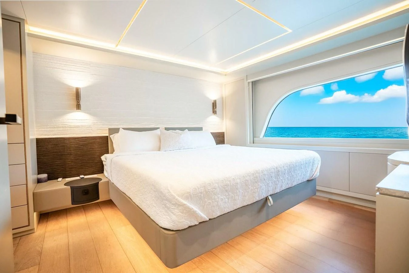 A luxurious stateroom featuring a large bed and a scenic ocean view through a wide window. aboard LADY SADIE Yacht for Sale