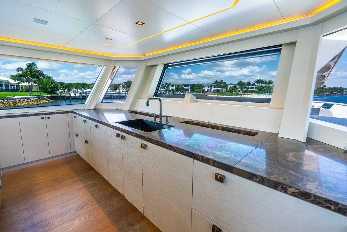 The yacht's galley features modern cabinetry and expansive windows with a scenic view. aboard LADY SADIE Yacht for Sale