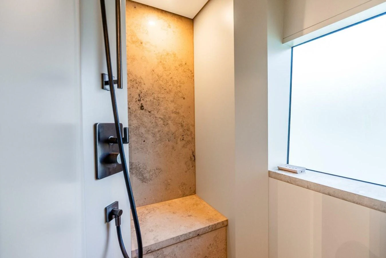 A modern shower area with elegant fixtures and natural stone accents. aboard LADY SADIE Yacht for Sale