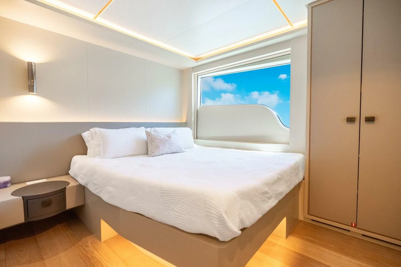 A luxurious stateroom featuring a large bed and modern decor with a view of the sky through the window. aboard LADY SADIE Yacht for Sale