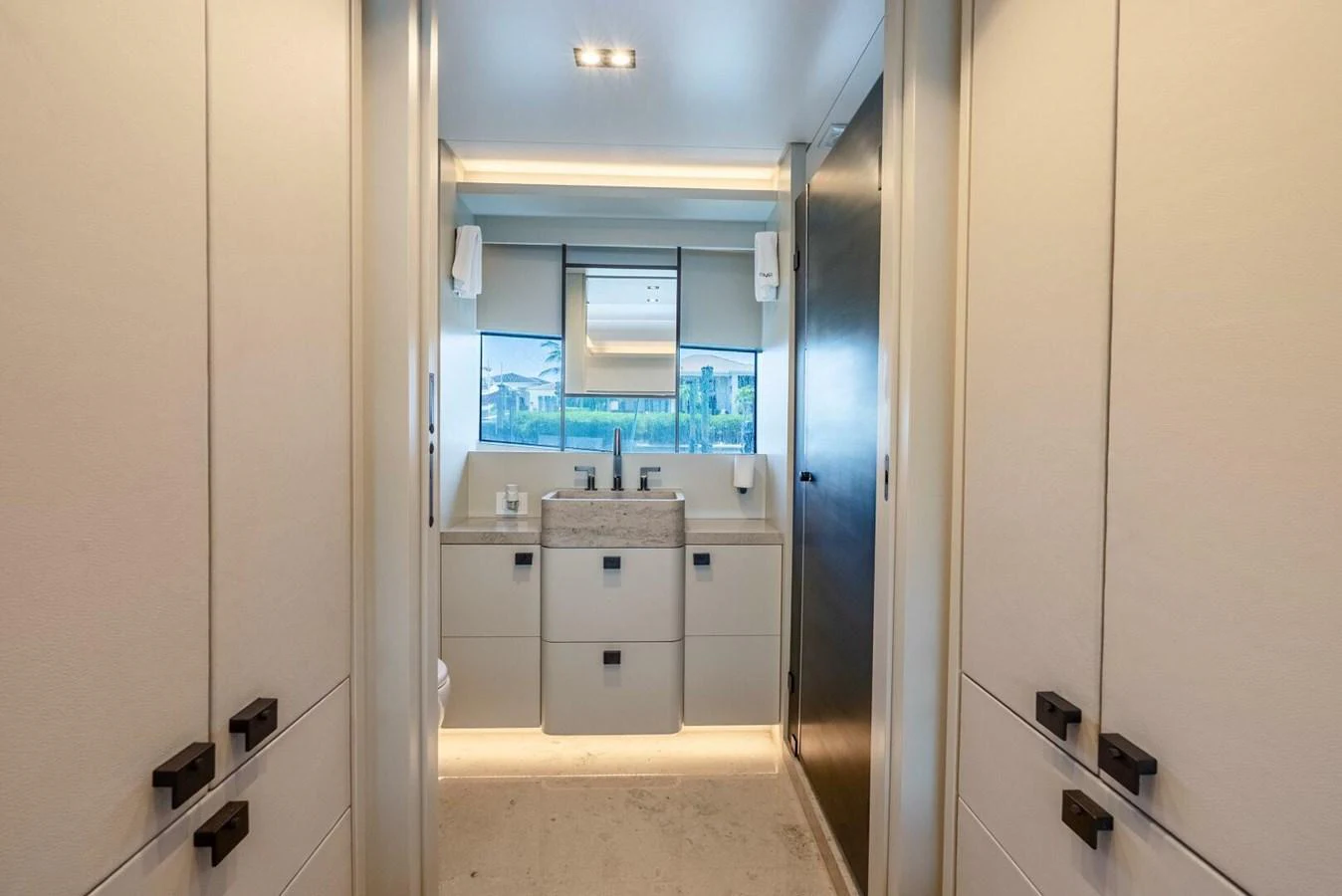 A modern bathroom with sleek cabinetry and a large window providing natural light. aboard LADY SADIE Yacht for Sale