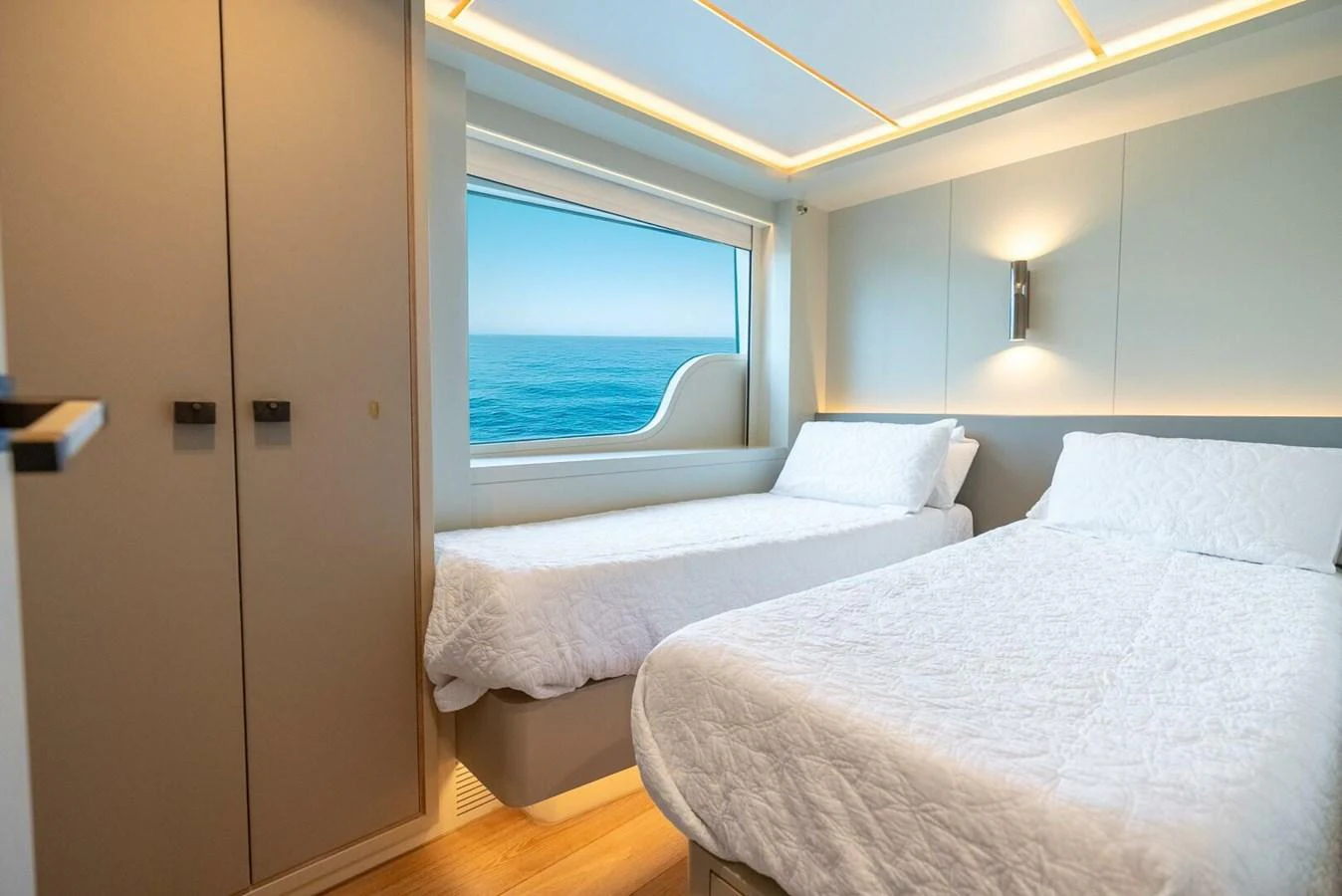 The guest stateroom features two comfortable twin beds and a large window with a stunning ocean view. aboard LADY SADIE Yacht for Sale