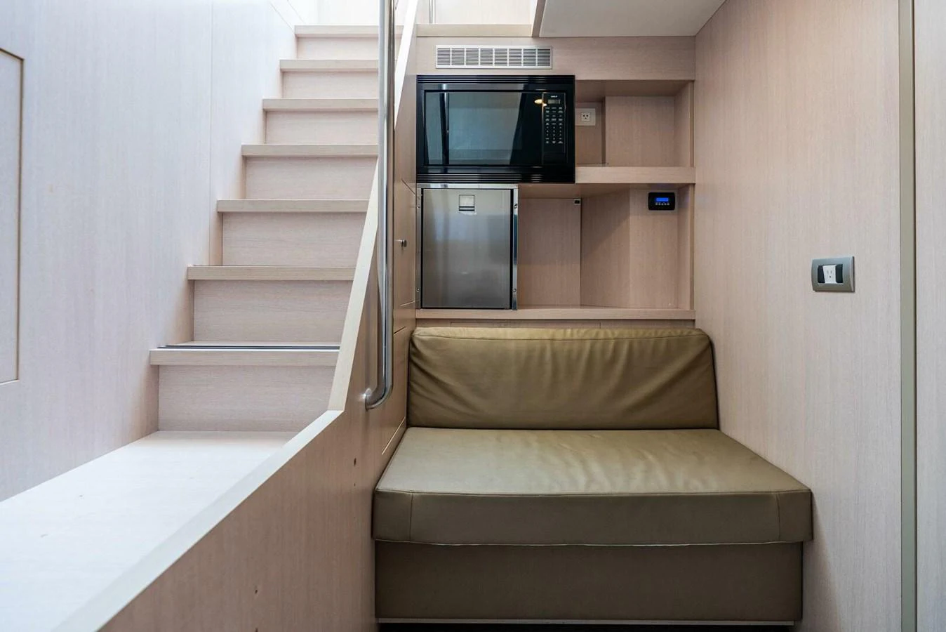 A cozy seating area with a microwave and mini-fridge, adjacent to a staircase. aboard LADY SADIE Yacht for Sale