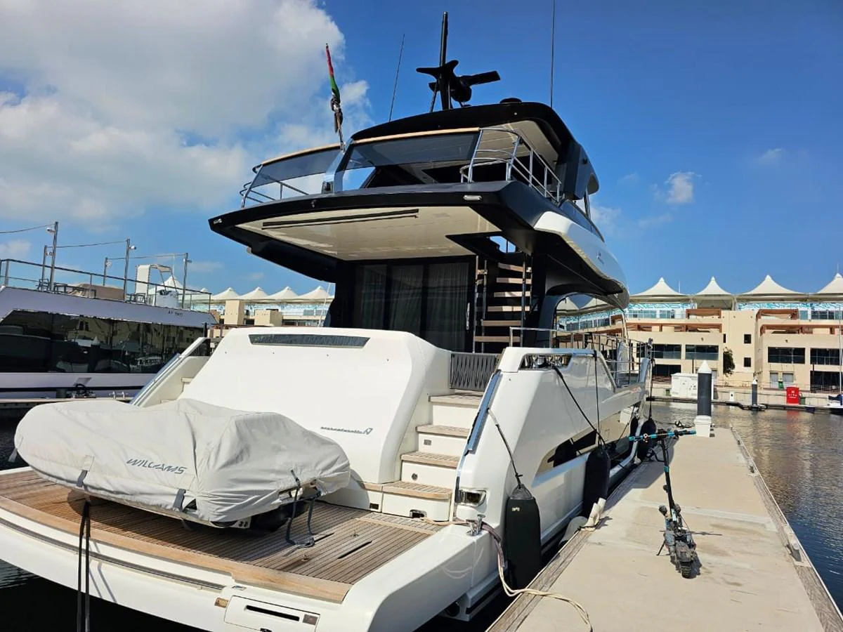 The yacht is docked at a marina, showcasing its spacious aft deck and modern design. aboard YAS 88 Yacht for Sale
