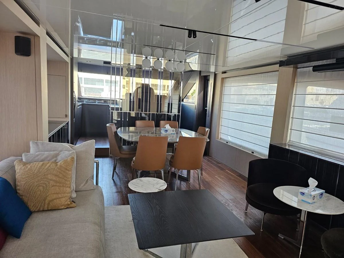 The yacht's salon features a comfortable seating area and a dining table with modern decor. aboard YAS 88 Yacht for Sale