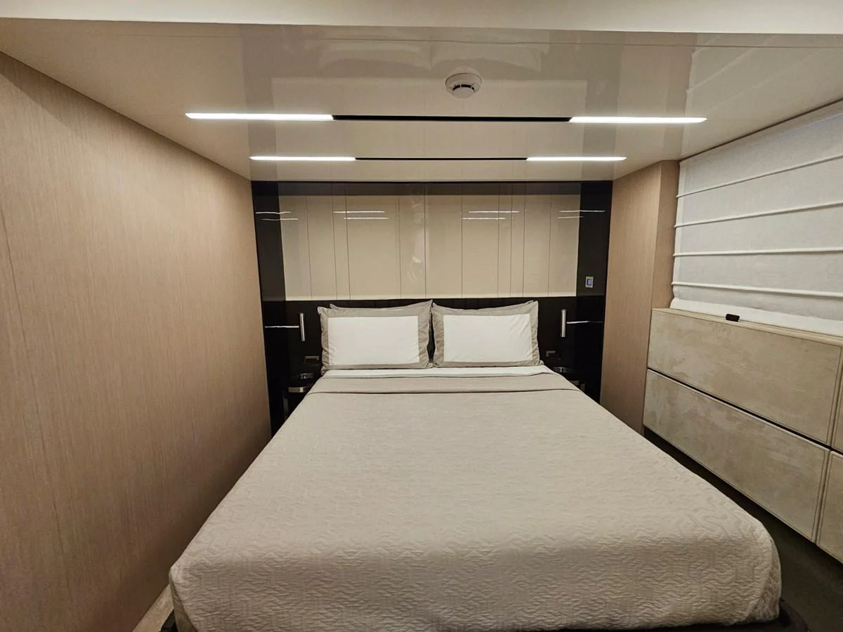 The stateroom features a comfortable bed with modern lighting and elegant decor. aboard YAS 88 Yacht for Sale