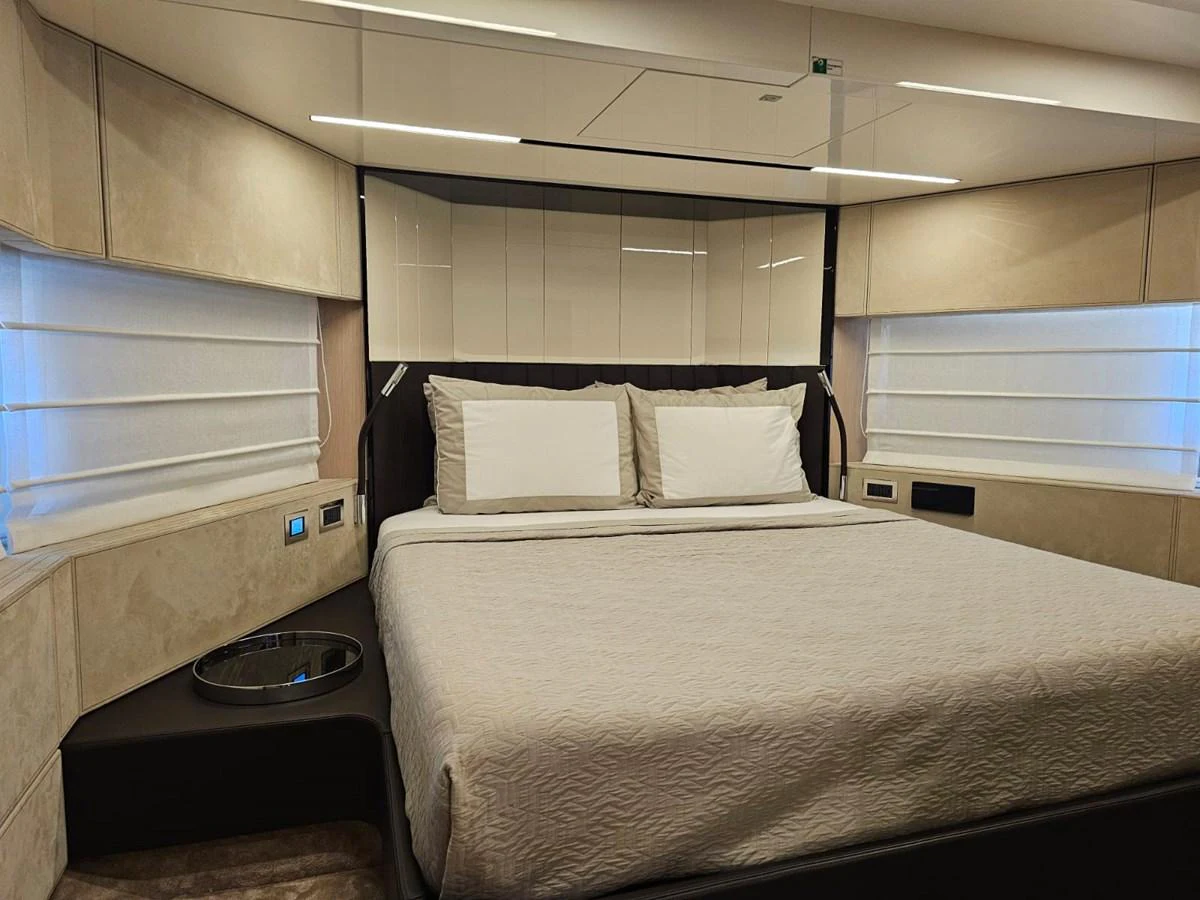 The master stateroom features a luxurious bed with elegant bedding and modern lighting. aboard YAS 88 Yacht for Sale