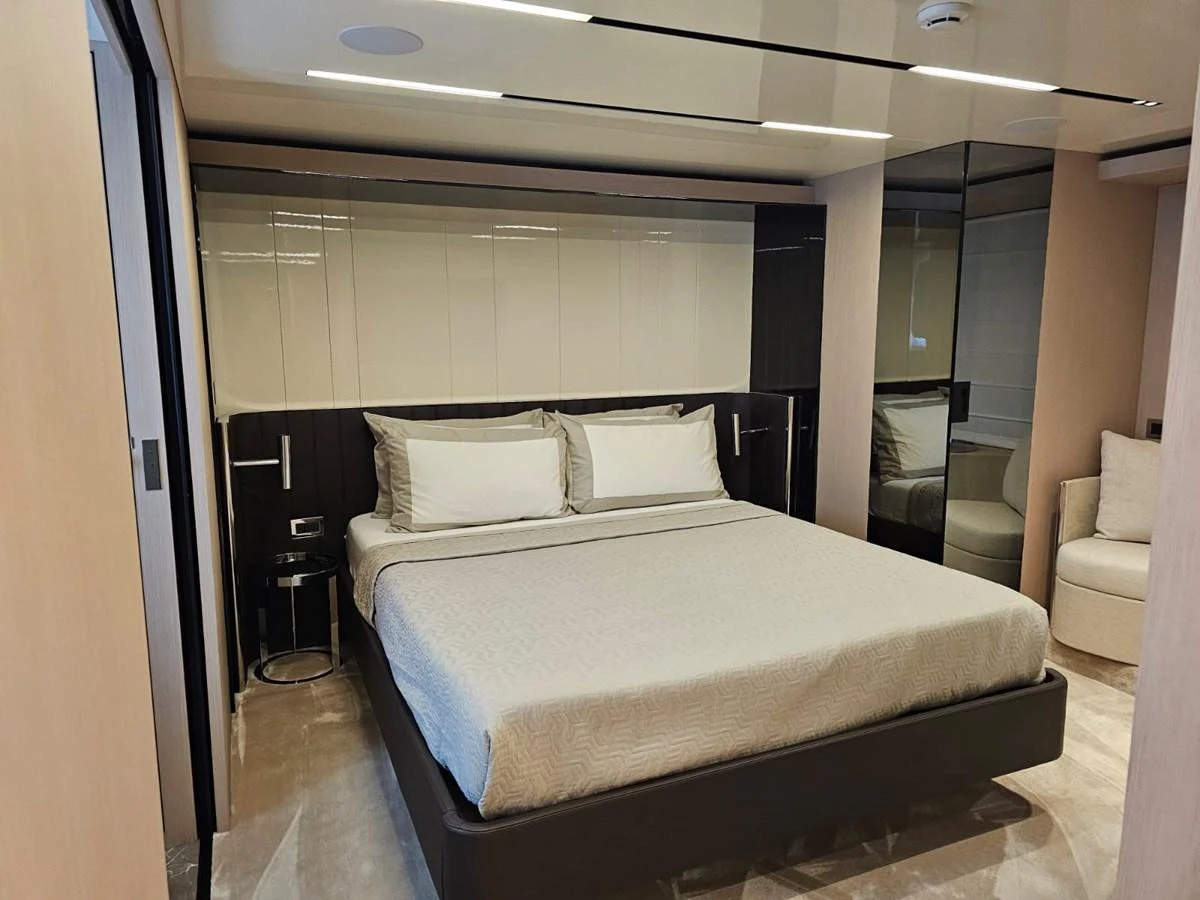 The master stateroom features a luxurious bed with modern decor and ample lighting. aboard YAS 88 Yacht for Sale
