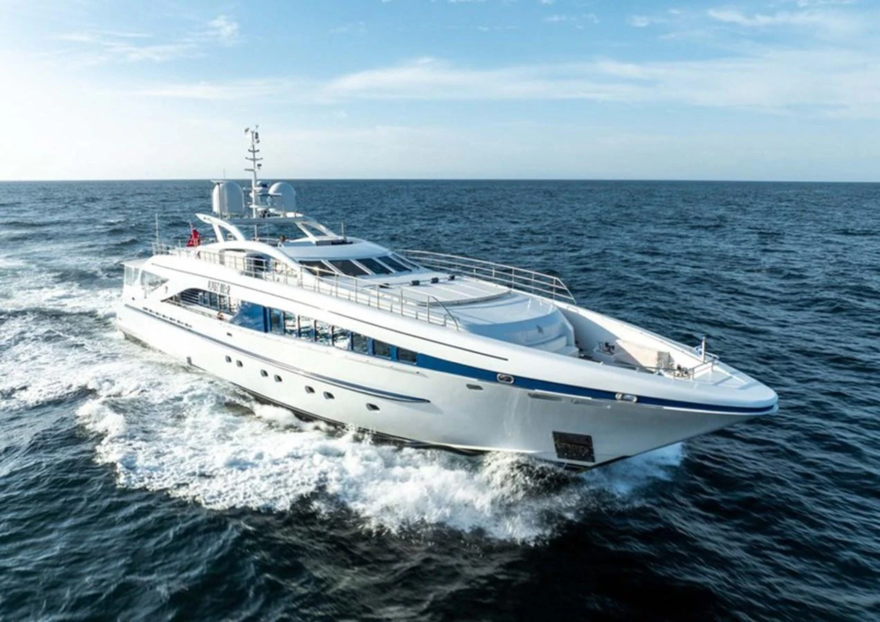 A sleek and modern yacht cruises swiftly through the open sea under a clear blue sky. aboard LUMIR Yacht for Sale
