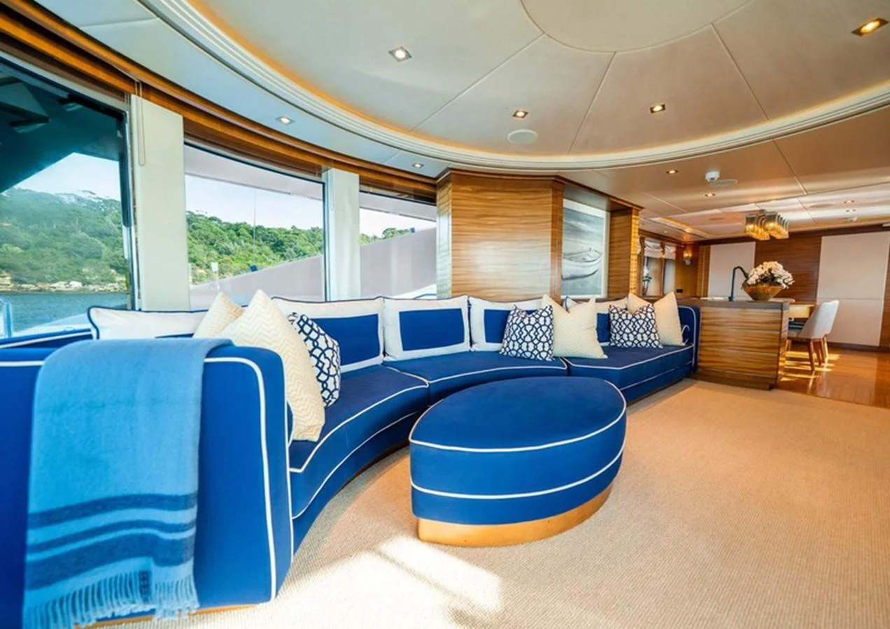 The salon features a spacious and elegant seating area with large windows offering scenic views. aboard LUMIR Yacht for Sale