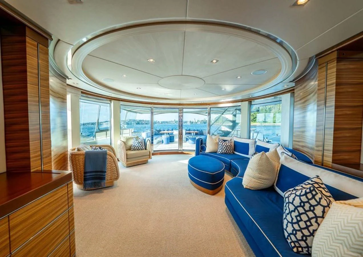 The salon features luxurious seating with panoramic views through large windows. aboard LUMIR Yacht for Sale