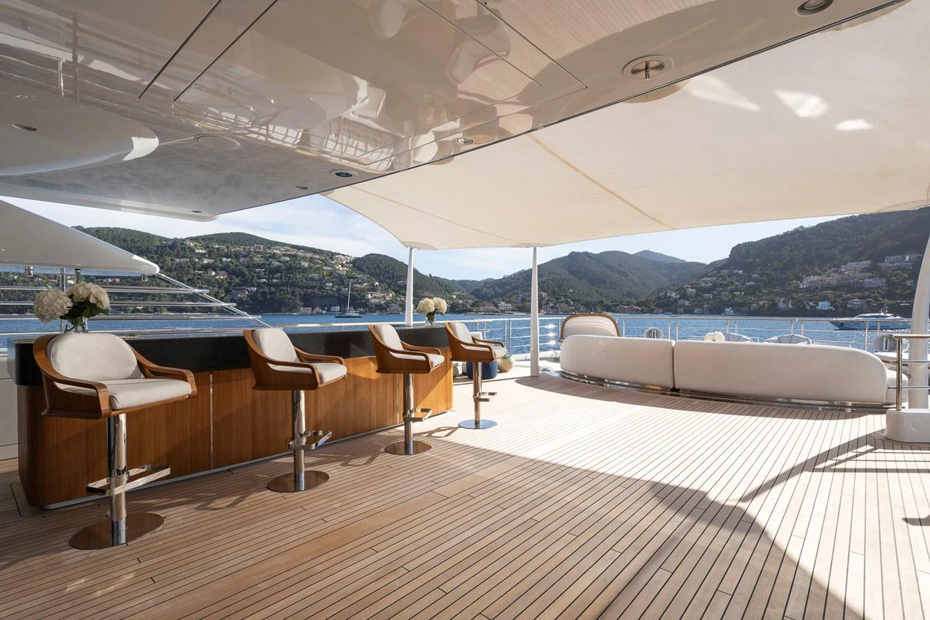 The spacious aft deck offers a luxurious setting with bar seating and panoramic views. aboard SYNTHESIS Yacht for Sale