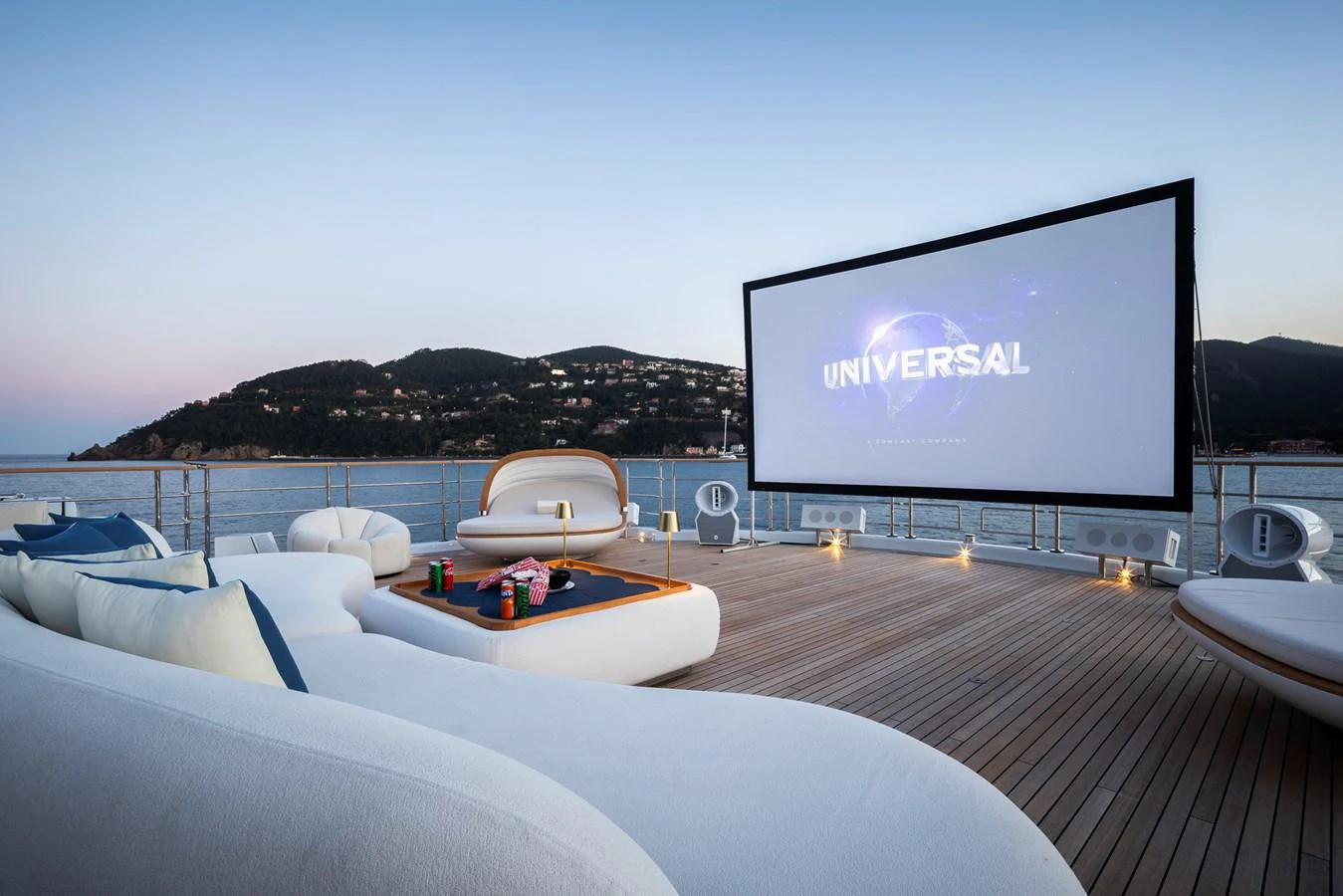 The yacht features a luxurious outdoor cinema with plush seating and a large screen, perfect for evening entertainment. aboard SYNTHESIS Yacht for Sale