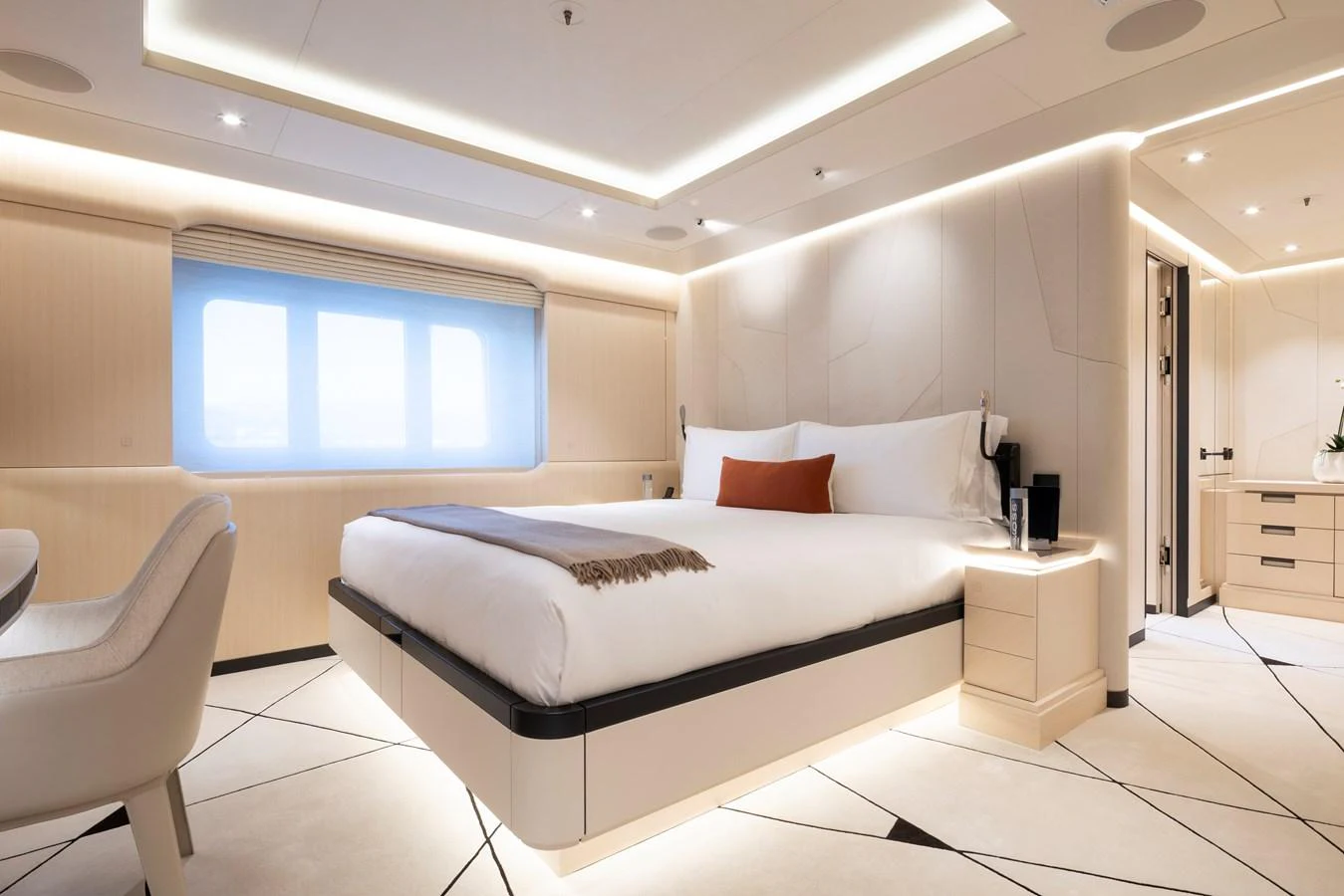 The stateroom features a luxurious bed with modern lighting and elegant decor. aboard SYNTHESIS Yacht for Sale