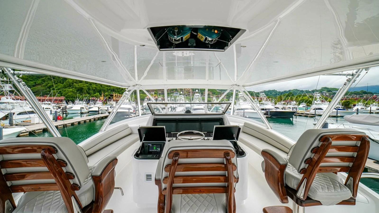 The helm station offers a commanding view of the marina, featuring luxurious seating and advanced navigation equipment. aboard FREE SPOOL Yacht for Sale