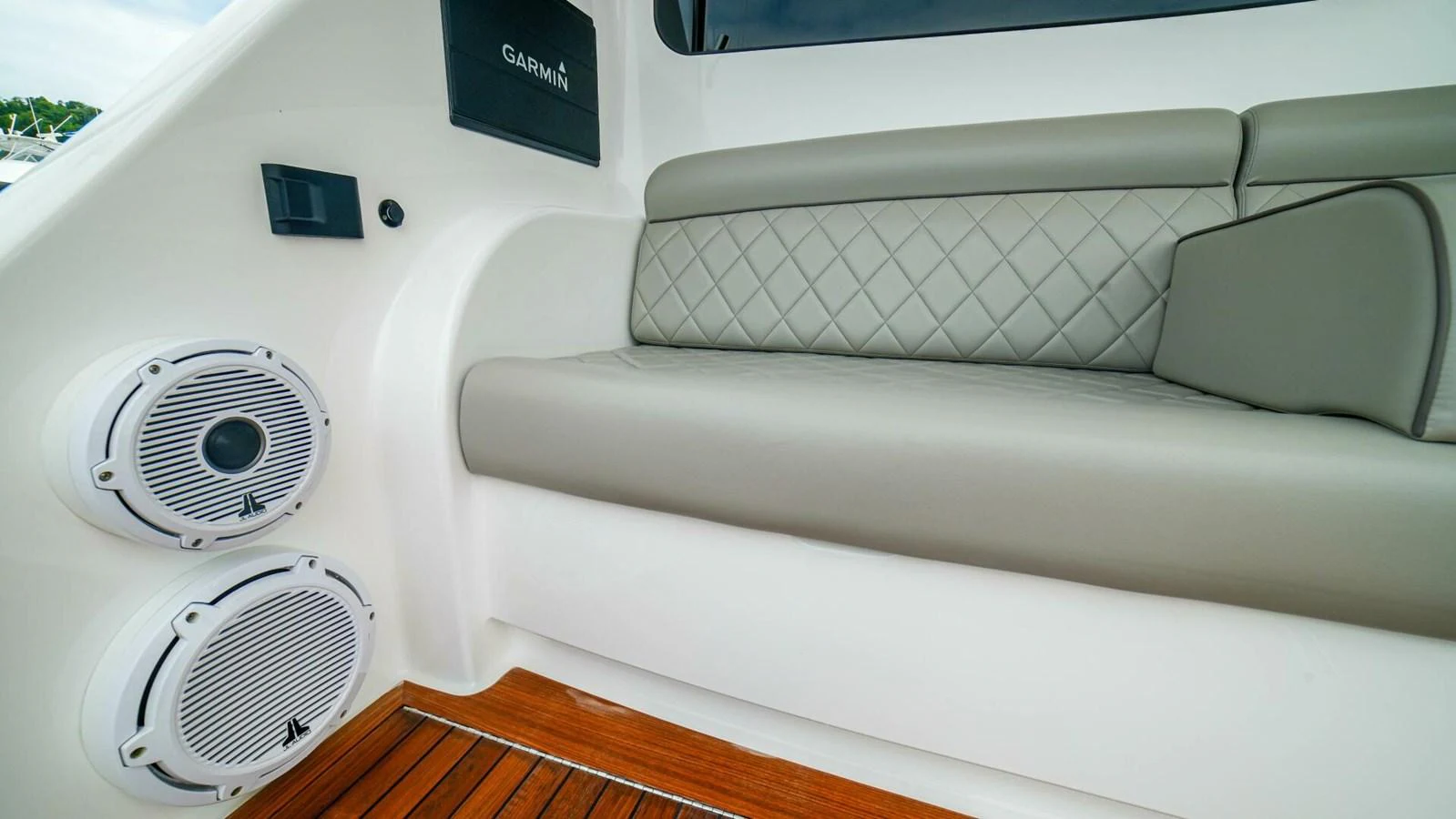 The image showcases a comfortable seating area with integrated speakers and a Garmin device. aboard FREE SPOOL Yacht for Sale