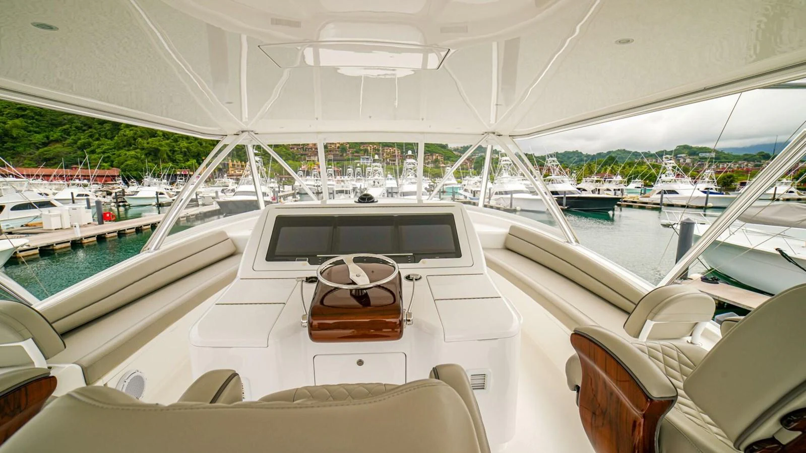 The helm station offers a commanding view of the marina with luxurious seating and advanced navigation equipment. aboard FREE SPOOL Yacht for Sale